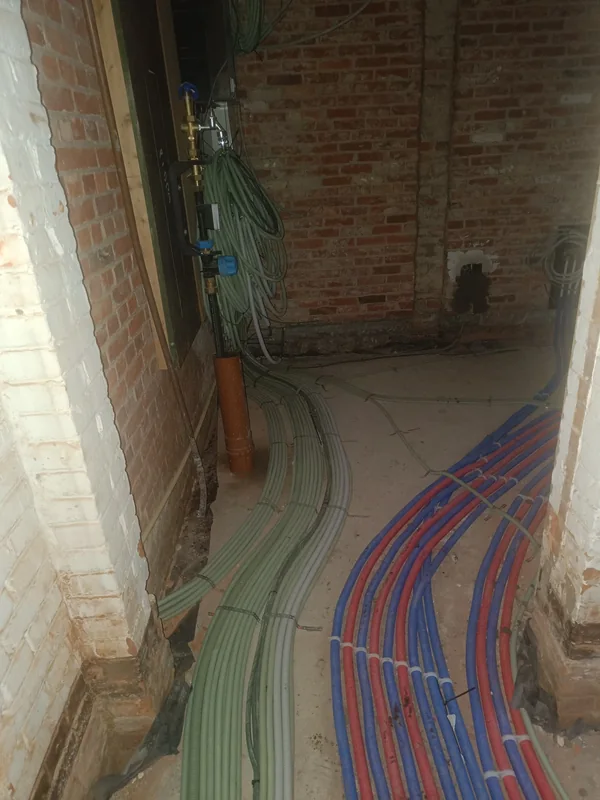 Elektrische leidingen over de vloer naar de technische ruimte in een woning in renovatie