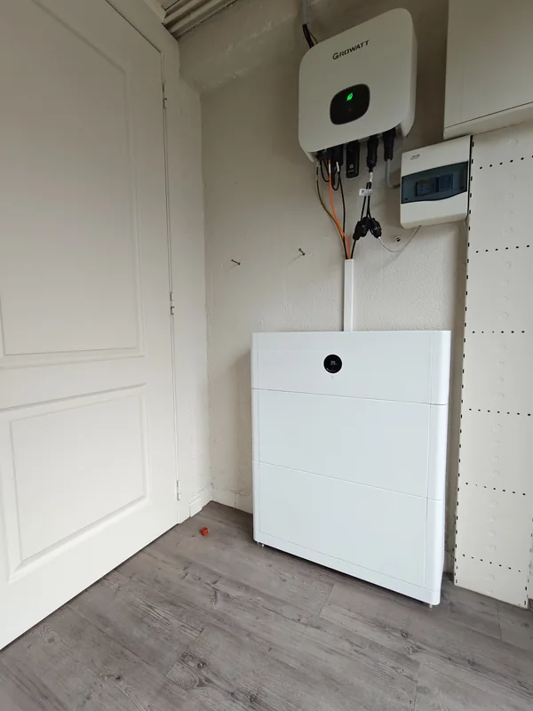 Growatt-omvormer boven een modulaire thuisbatterij in een technische ruimte in Herenthout
