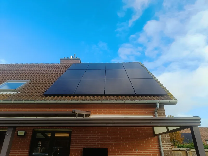 Zwarte zonnepanelen in een aaneengesloten vlak op een pannendak bij een woning in Hulshout