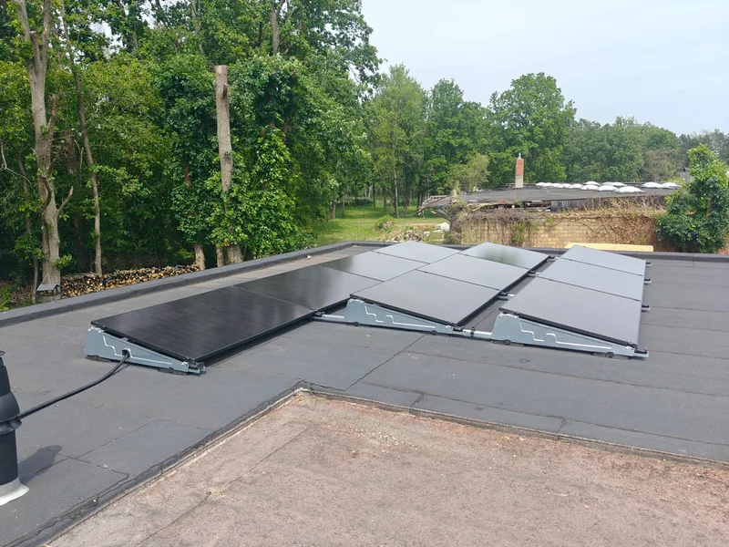 Overzicht van door EWN geplaatste zwarte zonnepanelen op een plat dak in Kessel